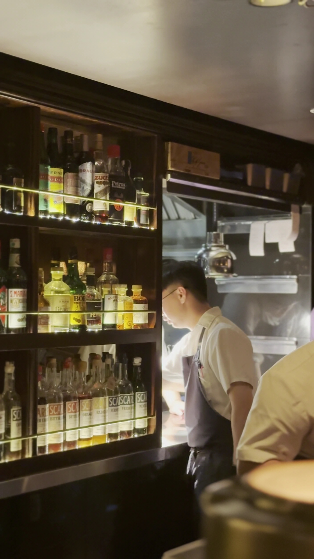 A view into the bar and open kitchen from the dining room